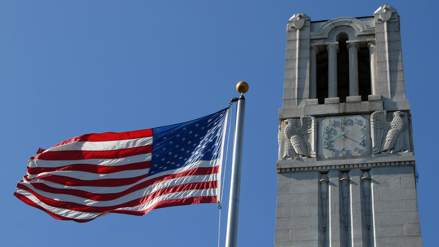 American flag waves in the Fall breeze next to the Belltower