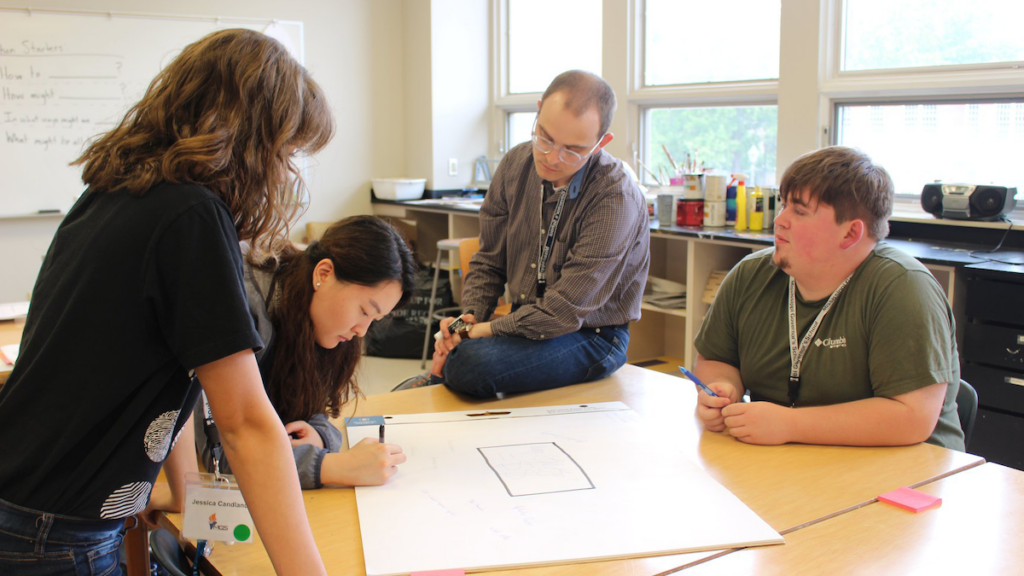 Jonathan Williams sits at a table with students.