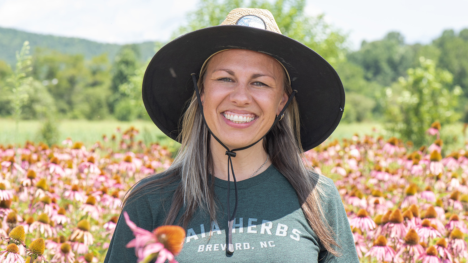 Woman smiling in field of pink flowers